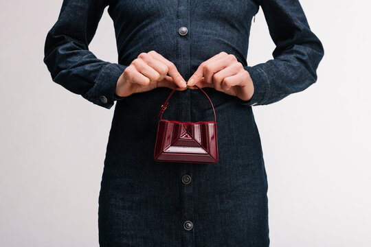 Small Red Handbag Held Over Denim Dress