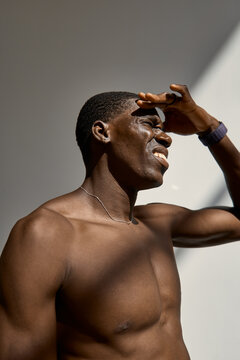 Man shielding eyes from sunlight in a bright room
