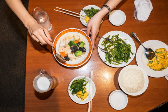 Diners Sharing Chinese Food Around Restaurant Table