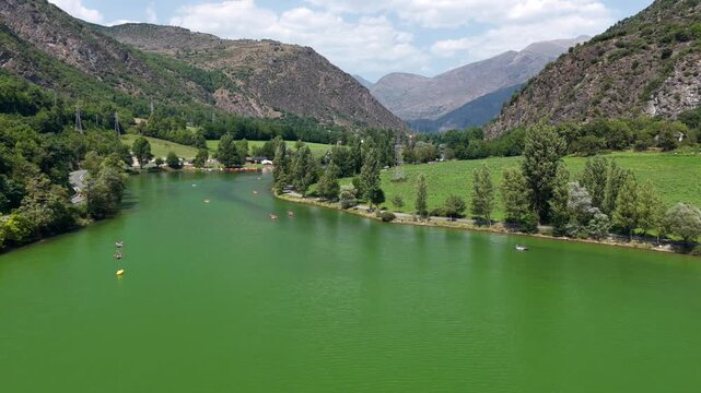 Aerial view of Lake Torrassa bright green algal bloom caused by extreme heatwave, Pyrenees, Spain"