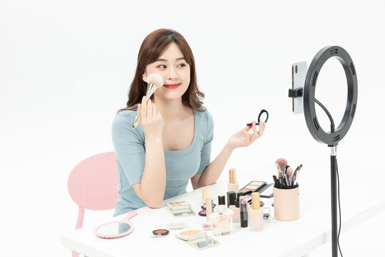 Young Asian Woman Livestreaming Makeup Tutorial with Ring Light and Smartphone