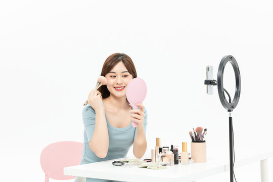 Smiling Asian Beauty Influencer Recording Makeup Tutorial with Ring Light and Smartphone