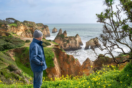 Man overlooking rugged coastal cliffs and ocean
