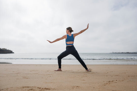 Woman Practicing Tai Chi on a Sandy Beach