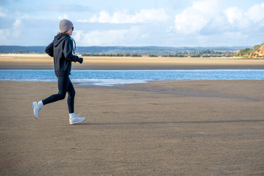 Woman Jogging on a Sandy Beach