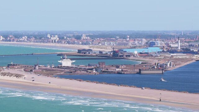 Aerial drone view of the seaport in Dunkirk, France. Industrial docks, cargo terminals, and commercial ships near the coastline.
