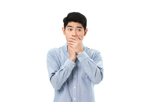 Scared Young Man Covering Mouth with Hands in Shock