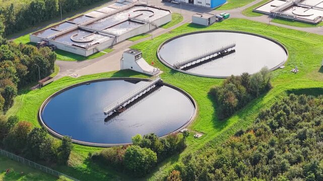Aerial drone view of a water treatment plant facilities. Circular sedimentation tanks and filtration basins at a modern sewage facility.