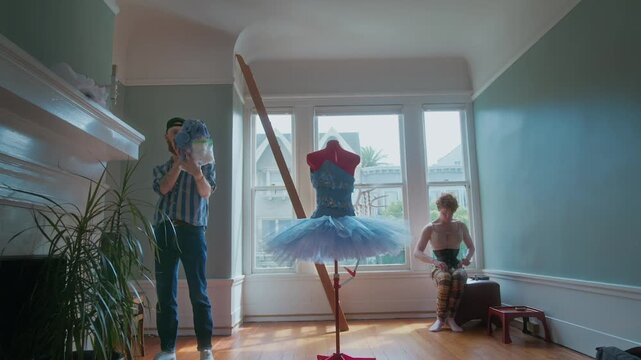 Two young men getting ready for a show in a dance studio with a tutu on a mannequin