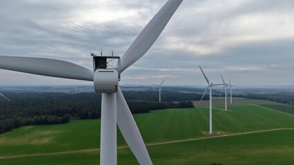 duże białe wiatraki elektrownie wiatrowe turbiny wiatrowe stojące na tle krajobrazu rolniczego © Adam Schmidt