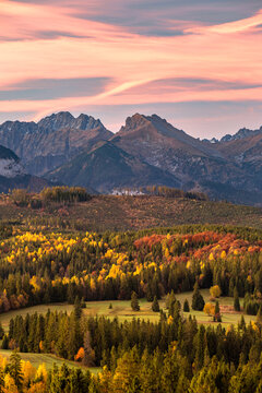 Majestic panoramic view of the Tatra Mountains landscape featuring snow-capped peaks, colorful forests, and picturesque valleys under a dramatic sky. Beautiful scenic nature and wilderness background