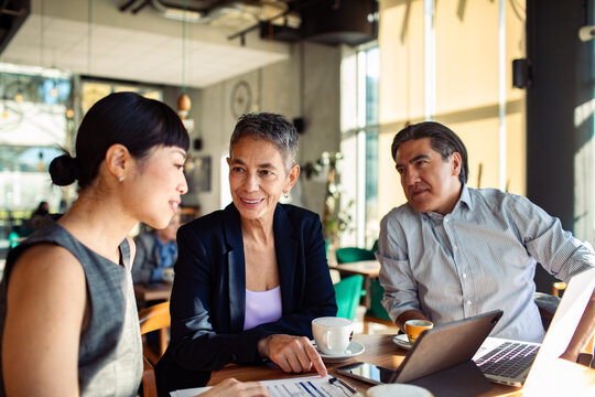 Colleagues reviewing report over coffee in a cafe