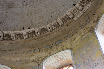 Ornate painted ceiling with decorative plaster frieze inside historic building. Interior architectural detail. Religious architecture and heritage preservation. Fresco ornament © Natalia