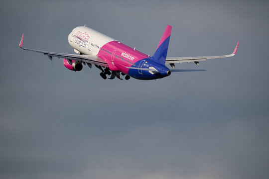 Wizz Air passenger airliner ascending into gray cloudy sky after departure in Gdansk, Poland