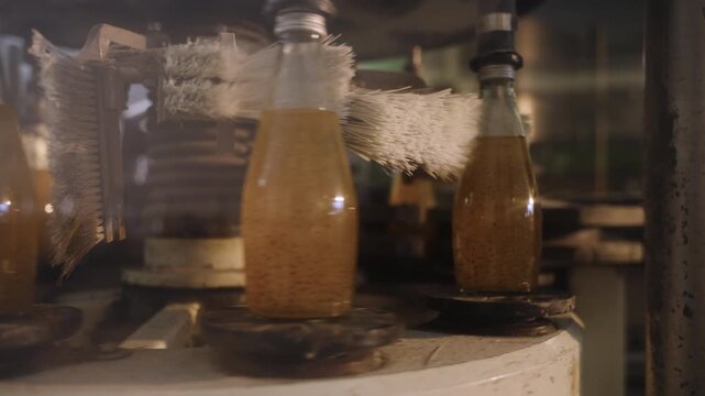 Juice in glass bottles on an automated conveyor belt in a modern beverage production facility line. Technology in the food and drink industry. Ready to drink fruit juice in a manufacturing factory. 