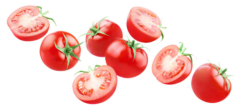 Whole and halved ripe red tomatoes floating, isolated on transparent cutout background