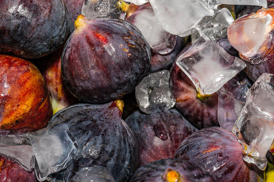 Fresh ripe purple figs, whole and halved, showing the juicy red pulp.