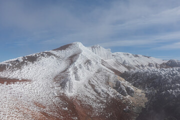 Scenic view of the snow covered volcanic ridge and volcanic rocks of Avachinsky volcano in Kamchatka Krai, Russia, showing dramatic arctic terrain under clear blue sky on a cold winter day © TravelFlow
