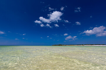 Tropical sandy beach and an exotic view of the Atlantic Ocean against a blue sky with clouds in Cuba, Caribbean – background for projects, wallpaper © anettastar
