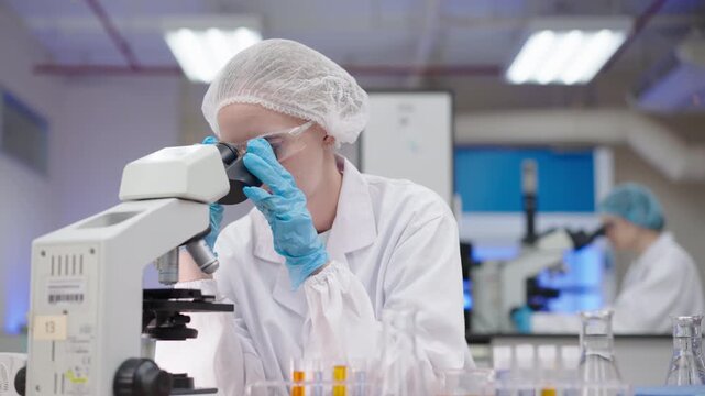 Medical Laboratory Researcher and Scientist Examining Specimen Through Microscope for Cosmetic Innovation, Healthcare Science Discovery, and Sterile Laboratory Research with Focus and Precision