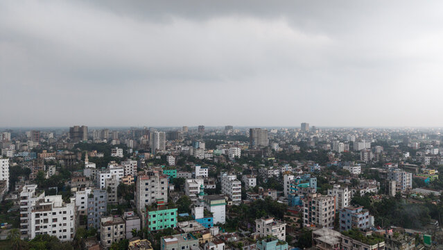 Aerial view of a densely populated urban cityscape in bangladesh with numerous residential apartment buildings under a cloudy grey sky