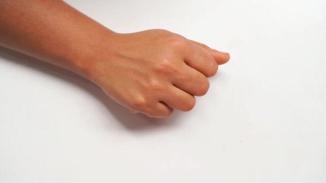Human Hand Making a Closed Fist Gesture Against Plain White Background.