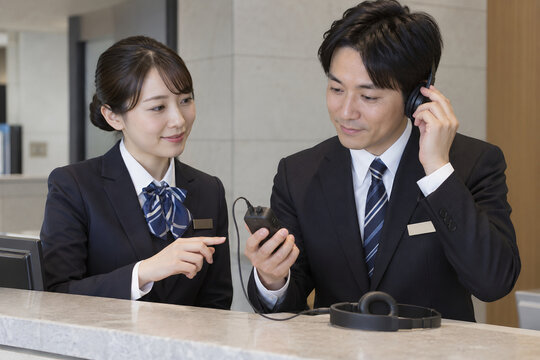 受付カウンターの磁気ループ受信機を確認する職員