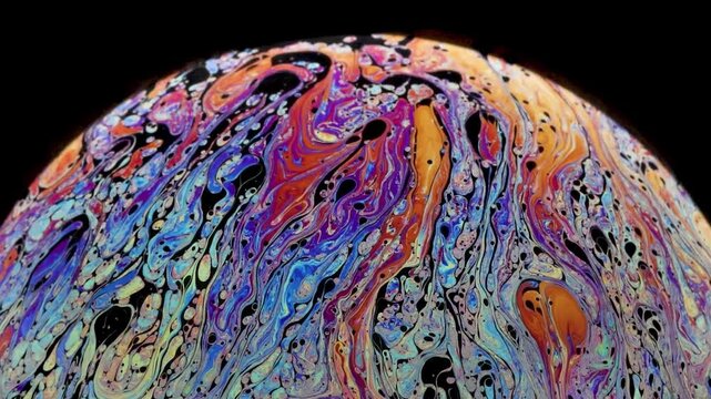 Soap bubble starting to loose cohesion as fragmentation shows up and really thin black of film layer going up and accumulation at the top of the bubble.