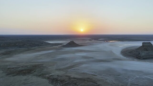 Setting Sun Behind Layered Buttes on the Karynzharyk Salt Flat