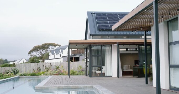 Camera is panning right, revealing backyard house and pool deck with pergola to showcase features