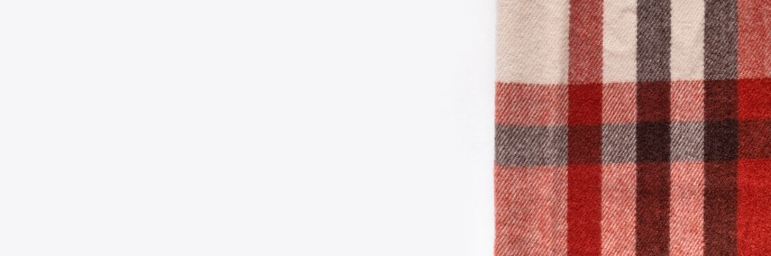 Warm autumn plaid textile fills frame, showing red, beige and gray woven checks with soft texture and open space. Patterned fabric suits scarf design, clothing concepts and seasonal retail visuals.
