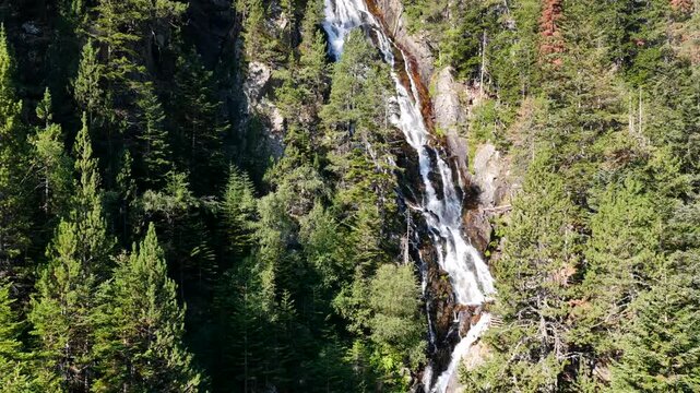 Aerial view of Cascada del Gerber waterfall plunging down granite cliffs near Aig&uuml;estortes National Park, Spanish Pyrenees