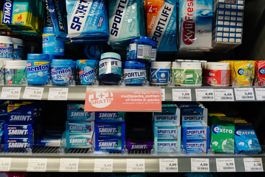 September 24, 2026, Amsterdam, Netherlands - Supermarket shelf displaying various brands of chewing gum and mints with price tags and a promotional offer