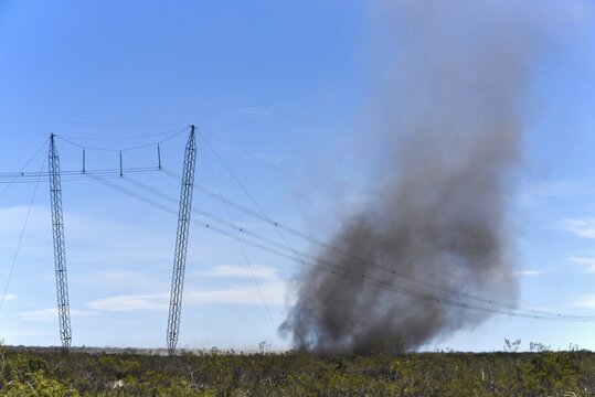 Power line with dust devil, sandstorm with lots of ash over burnt pampas, Patagonia, Argentina