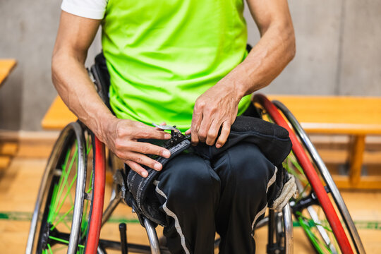 Athlete adjusting seatbelt on sports wheelchair before game