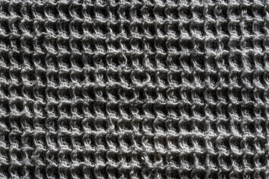 Waffle weave fabric texture grey cotton material background. Top view grey waffle towel texture. Full frame background of cellular cotton or linen woven fabric for eco friendly home textile design