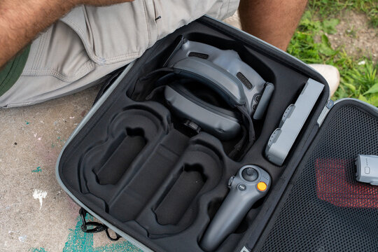 Drone carrying case organizer with VR goggles, remote controller and spare batteries neatly stored inside, showcasing portable equipment protection, smart storage solutions