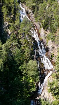 Aerial view of Cascada del Gerber waterfall plunging down granite cliffs near Aig&uuml;estortes National Park, Spanish Pyrenees