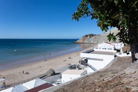 Elevated view of Burgau beach with white buildings and blue sea under a clear sky in Algarve, Portugal