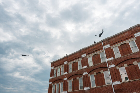 Military escort helicopters flying over brick buildings in Jefferson City, Missouri, July 2026