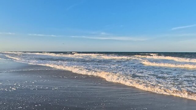  4K beach video follows a rightward sweep across parallel lines of surf.