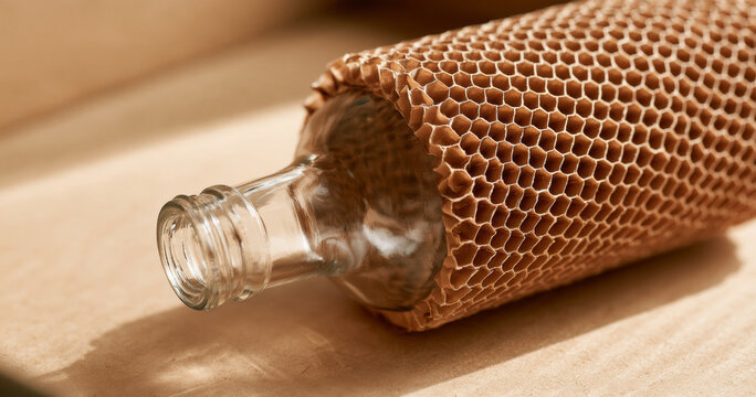 Honeycomb Covered Glass Bottle On Wooden Surface