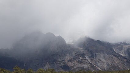 Clouds covering rocky peaks of Jade Dragon Snow Mountain in China © Zeyu
