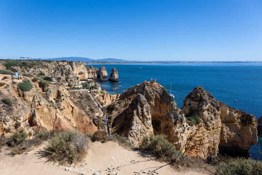 Golden sandstone cliffs and sea stacks overlooking the blue Atlantic at Ponta da Piedade, Algarve, Portugal