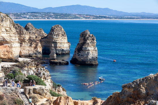 Sea stacks and golden cliffs at Ponta da Piedade with kayaks on turquoise water, Lagos, Algarve, Portugal