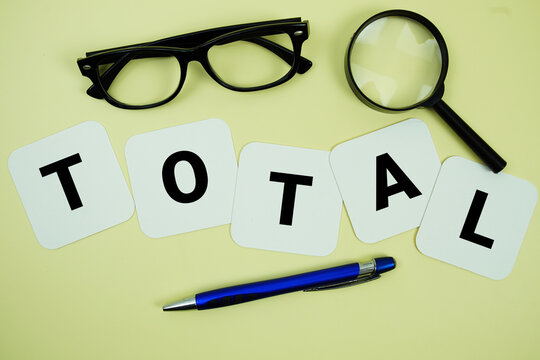 TOTAL alphabet letters with magnifying glass, eye glasses and pen on yellow background
