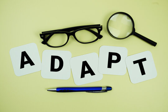 ADAPT alphabet letters with magnifying glass, eye glasses and pen on yellow background