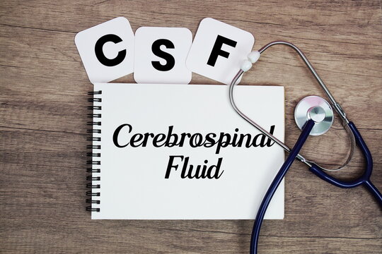 CSF Cerebrospinal Fluid text written on notepad with stethoscope on wooden background