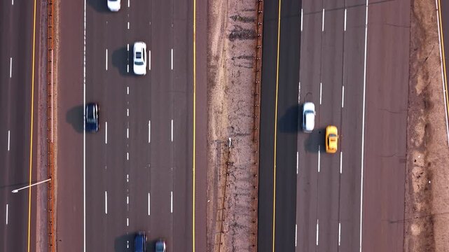 Asphalt multi-lane highway highways with moving cars. Bird's eye view on the motorways with sparse vehicle driving by.