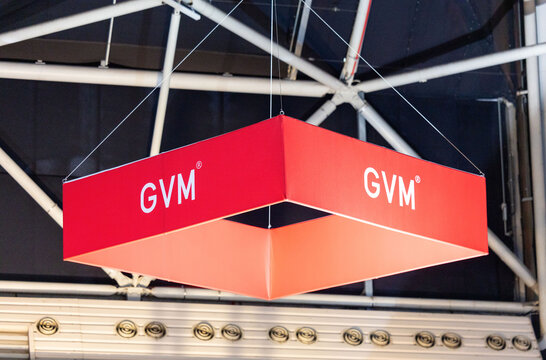 Amsterdam, Netherlands - September 11, 2026: GVM logo on a suspended red exhibition sign beneath a venue roof structure at the IBC media and technology trade show